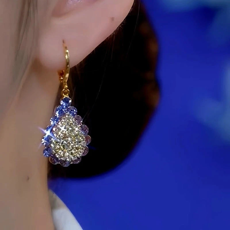 Model showcasing the dangle and style of the 14K Gold-Plated Diamond Drop Earrings
