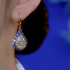 Model showcasing the dangle and style of the 14K Gold-Plated Diamond Drop Earrings