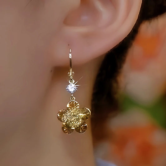 Model showcasing the dangle and style of the 14K Gold-Plated Diamond Flower Earrings