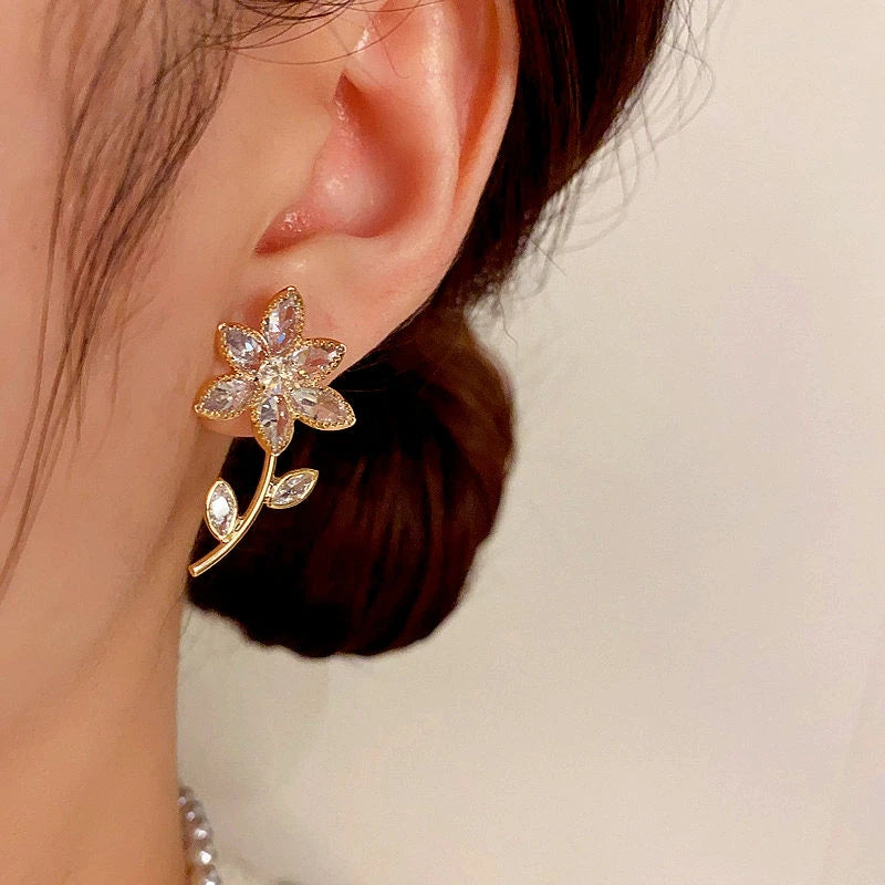 Model showcasing the dangle and style of the 14K Gold-Plated Diamond Flower Earrings
