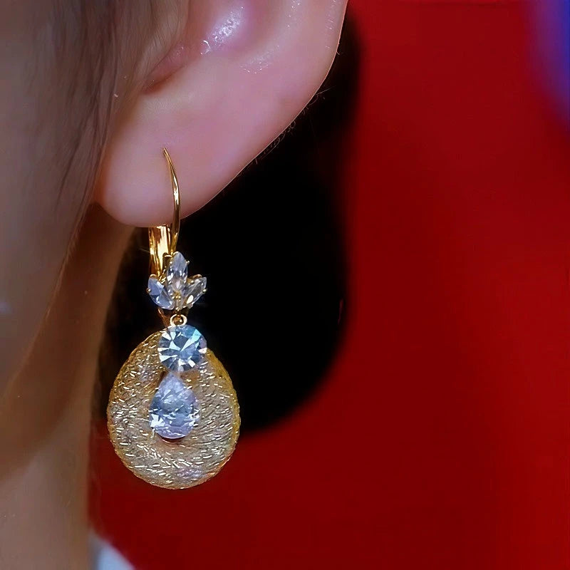 Model showcasing the dangle and style of the 14K Gold-Plated Diamond Flower Mesh Crystal Earrings