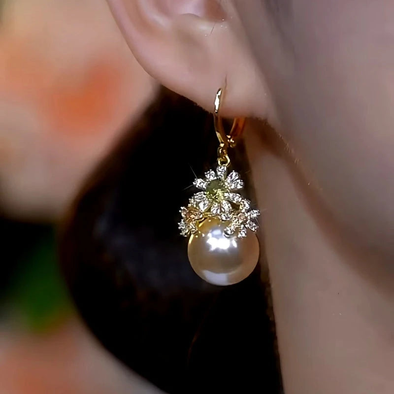 Model showcasing the dangle and style of the 14K Gold-Plated Diamond Flower Pearl Earrings