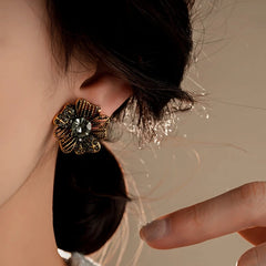 Model showcasing the dangle and style of the 14K Gold-Plated Diamond Flower Stud Earrings