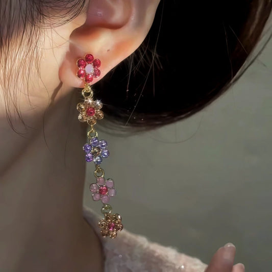 Model showcasing the dangle and style of the 14K Gold-Plated Diamond Flower Tassel Earrings