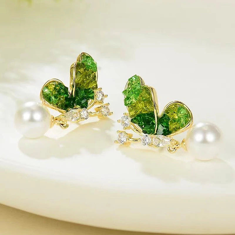 Model showcasing the dangle and style of the 14K Gold-Plated Diamond Gradient Green Butterfly Crystal Pearl Earrings