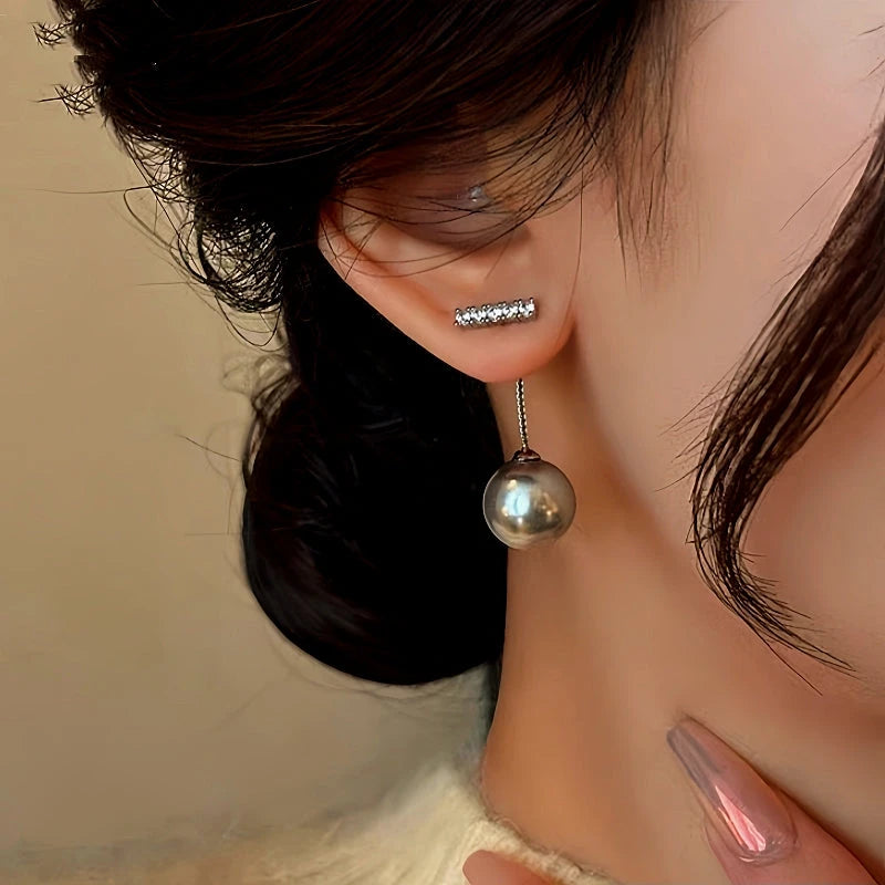 Model showcasing the dangle and style of the 14K Gold-Plated Diamond Gray Pearl Earrings