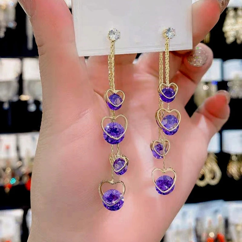 Model showcasing the dangle and style of the 14K Gold-Plated Diamond Heart-Design Earrings