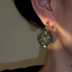 Model showcasing the dangle and style of the 14K Gold-Plated Diamond Heart Earrings