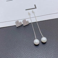 Model showcasing the dangle and style of the 14K Gold-Plated Diamond Heart Pearl Tassel Earrings