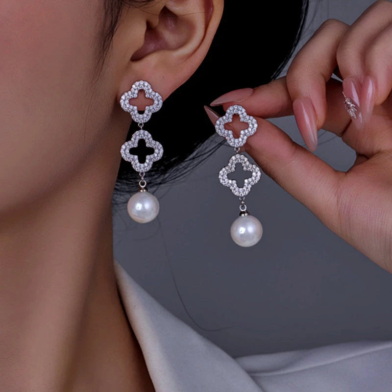 Model showcasing the dangle and style of the 14K Gold-Plated Diamond Hollow Four-Leaf Flower Pearl Earrings