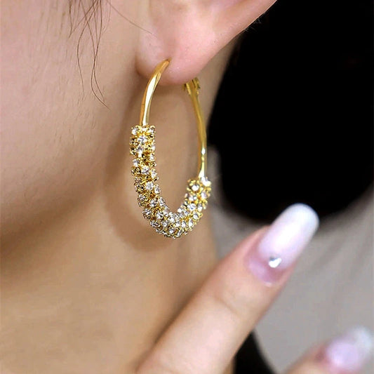 Model showcasing the dangle and style of the 14K Gold-Plated Diamond Hoop Earrings