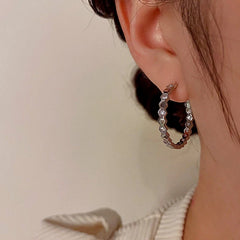 Model showcasing the dangle and style of the 14K Gold-Plated Diamond Hoop Earrings