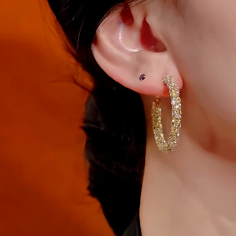 Model showcasing the dangle and style of the 14K Gold-Plated Diamond Hoop Earrings