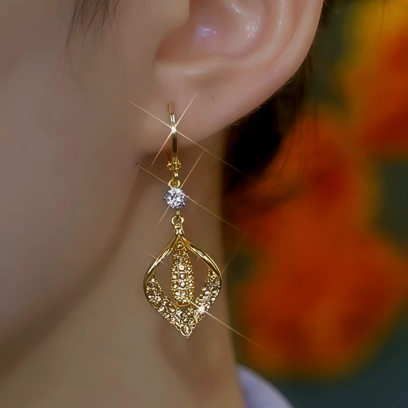 Model showcasing the dangle and style of the 14K Gold-Plated Diamond Leaf Earrings