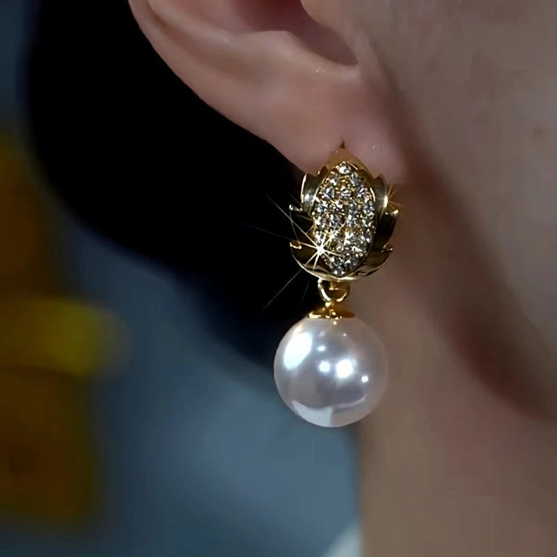 Model showcasing the dangle and style of the 14K Gold-Plated Diamond Leaf White Pearl Earrings