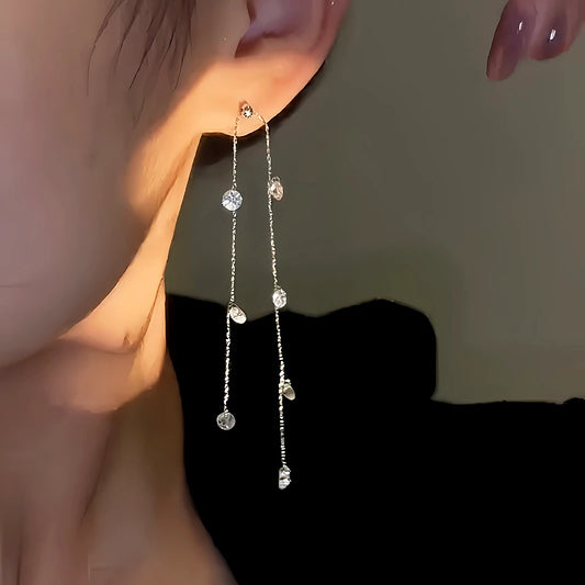 Model showcasing the dangle and style of the 14K Gold-Plated Diamond Long Tassel Earrings