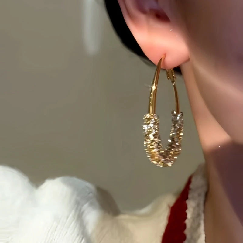 Close-up detail of the sparkling zircons and plating on the Oval Hoop Earrings