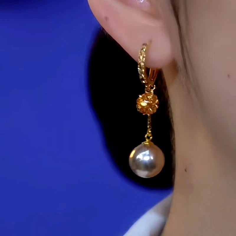 Model showcasing the dangle and style of the 14K Gold-Plated Diamond Pearl Earrings