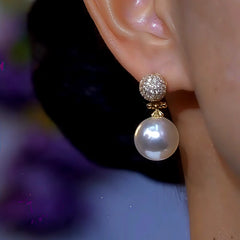 Model showcasing the dangle and style of the 14K Gold-Plated Diamond Pearl Earrings