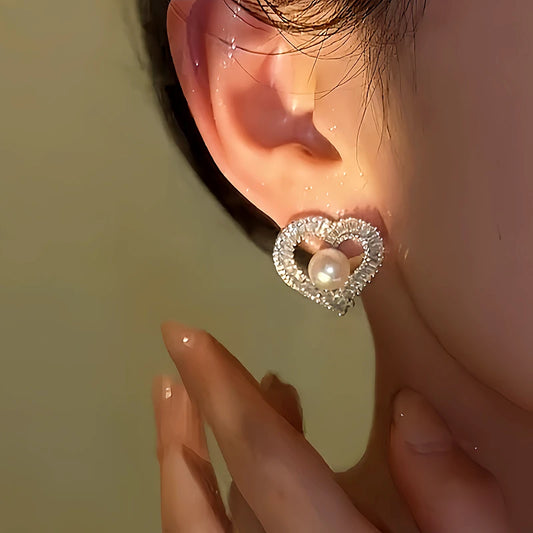 Model showcasing the dangle and style of the 14K Gold-Plated Diamond Pearl Heart-Design Stud Earrings