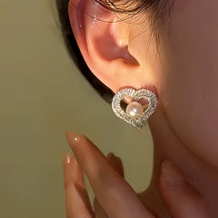 Model showcasing the dangle and style of the 14K Gold-Plated Diamond Pearl Heart-Design Stud Earrings