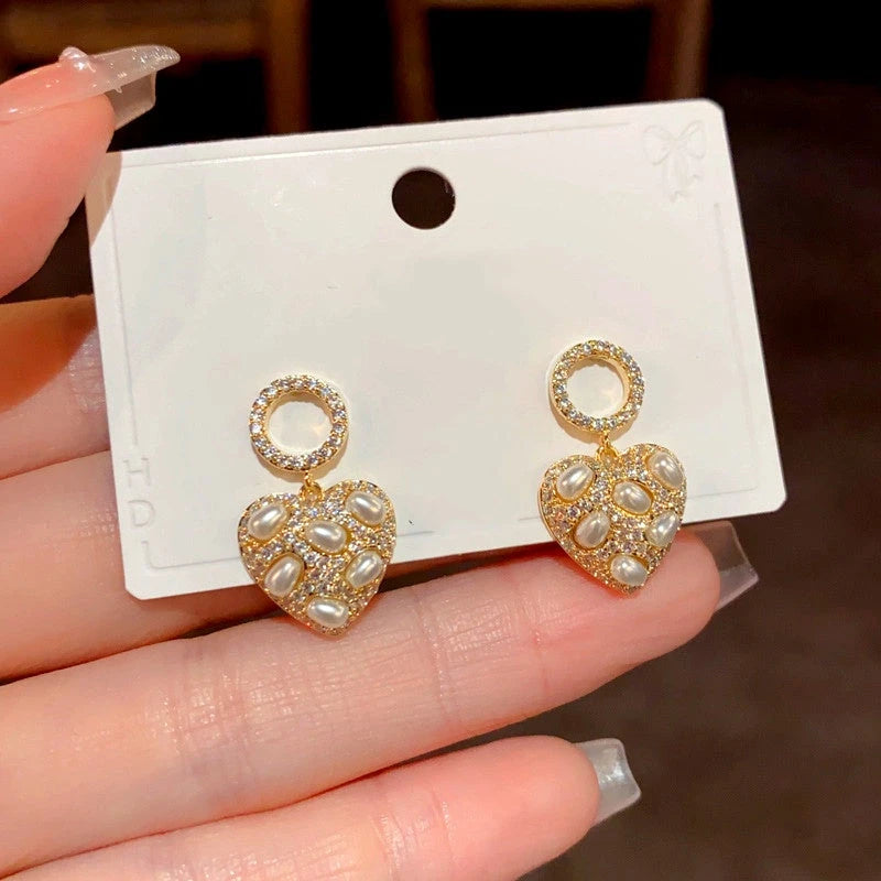 Angled view of the 14K Gold-Plated Diamond Pearl Heart Earrings