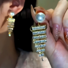 Model showcasing the dangle and style of the 14K Gold-Plated Diamond Pearl Tassel Earrings