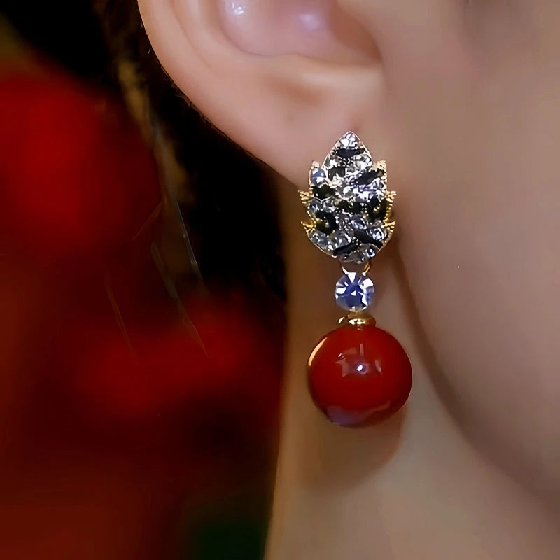 Model showcasing the dangle and style of the 14K Gold-Plated Diamond Red Pearl Earrings