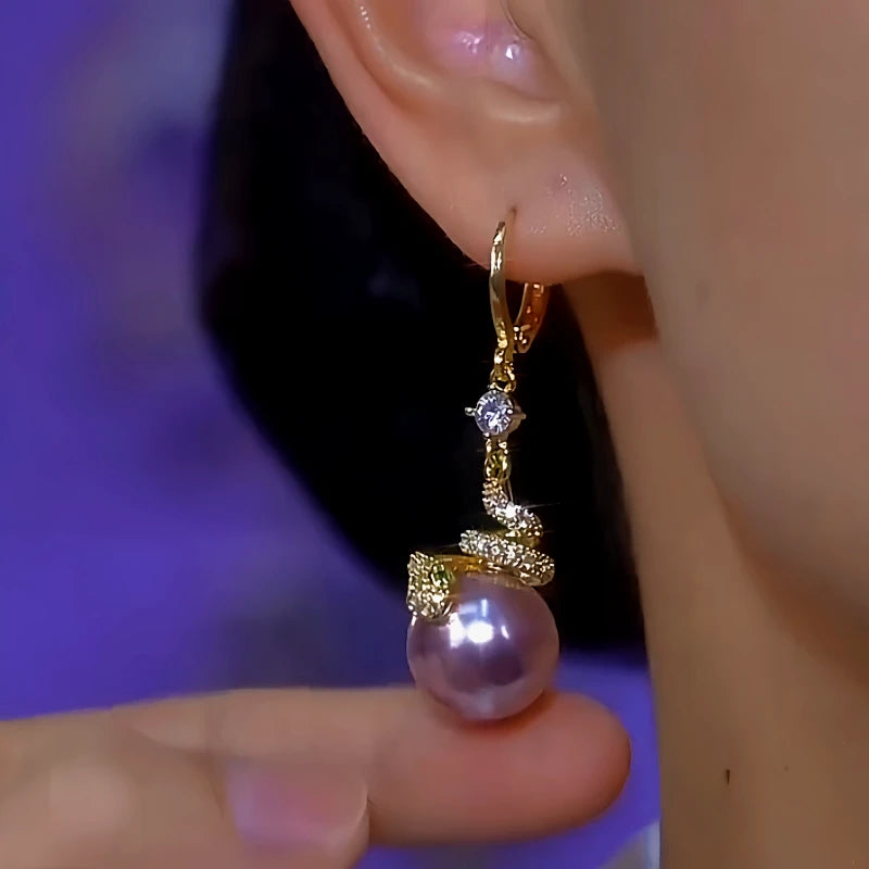 Model showcasing the dangle and style of the 14K Gold-Plated Diamond Snake Purple Pearl Earrings