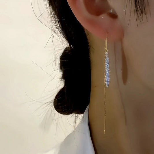 Model showcasing the dangle and style of the 14K Gold-Plated Diamond Tassel Threader Earrings