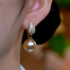 Model showcasing the dangle and style of the 14K Gold-Plated Diamond Tulip Brown Pearl Earrings
