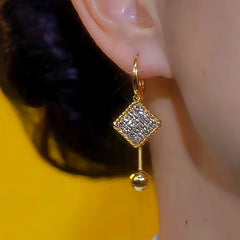 Model showcasing the dangle and style of the 14K Gold-Plated Diamond Water Drop Tassel Earrings
