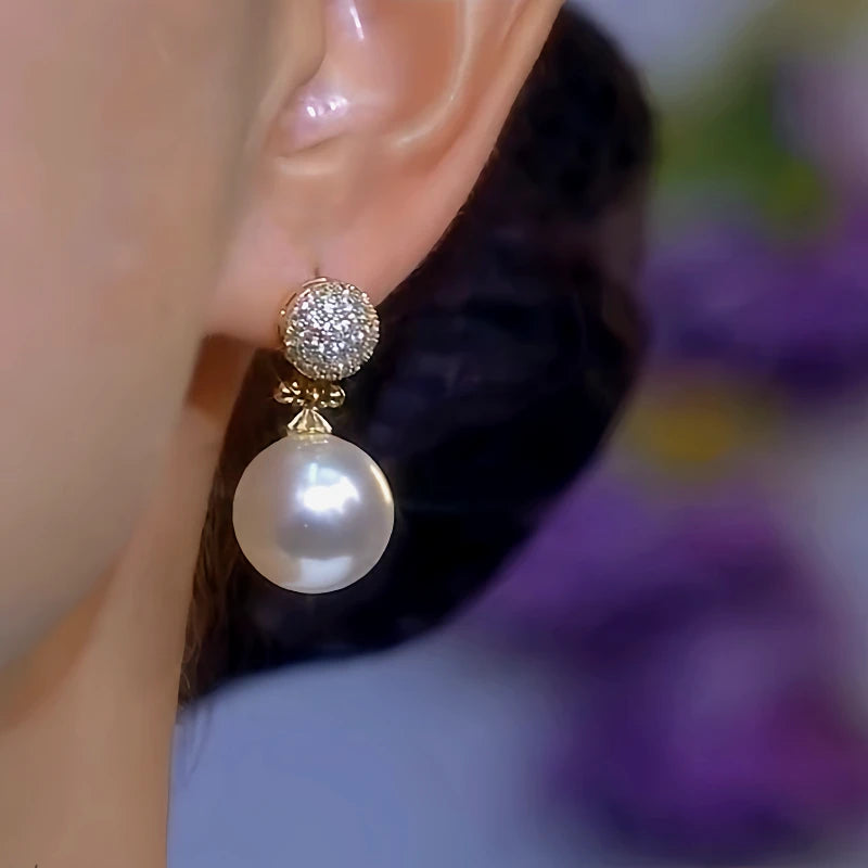 Model showcasing the dangle and style of the 14K Gold-Plated Diamond White Pearl Earrings