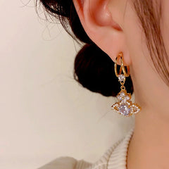 Model showcasing the dangle and style of the 14K Gold-Plated Diamond Zircon Planet Earrings