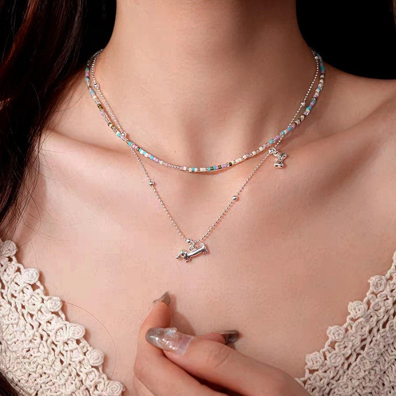 Detailed view of the 14K Gold-Plated Double-Layer Bead Puppy Necklace chain and pendant