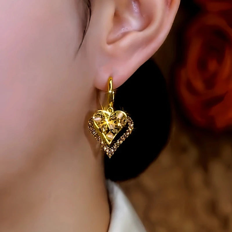Model showcasing the dangle and style of the 14K Gold-Plated Double-Layer Cat's Eye Stone Brown Diamond Heart Earrings
