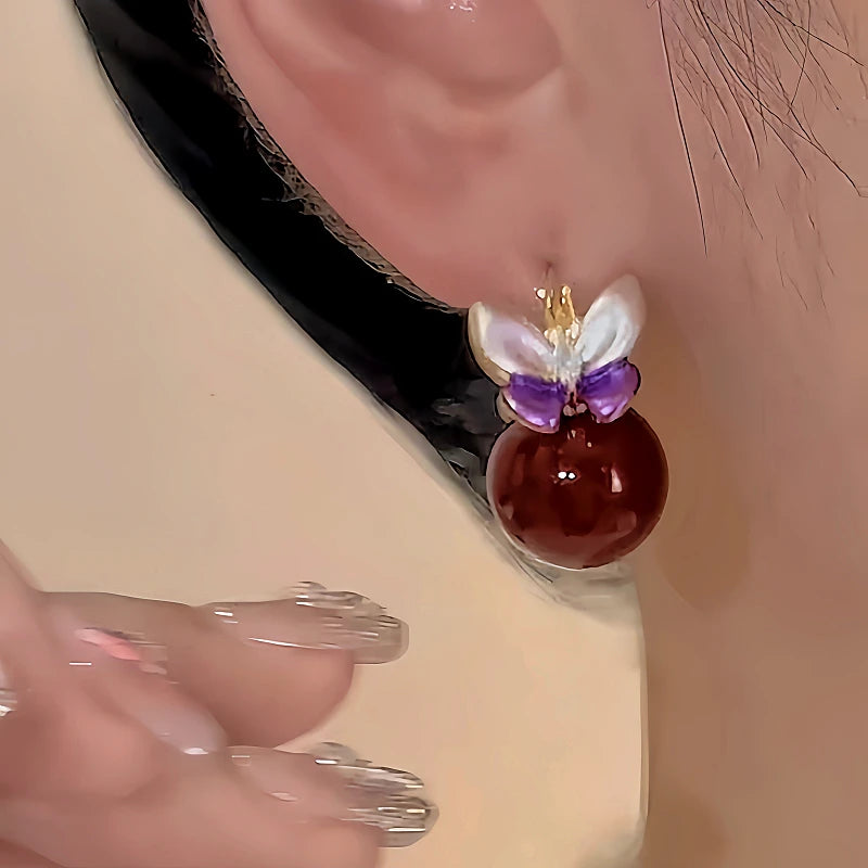 Model showcasing the dangle and style of the 18K Gold-Plated Double-Sided Butterfly Pearl Earrings