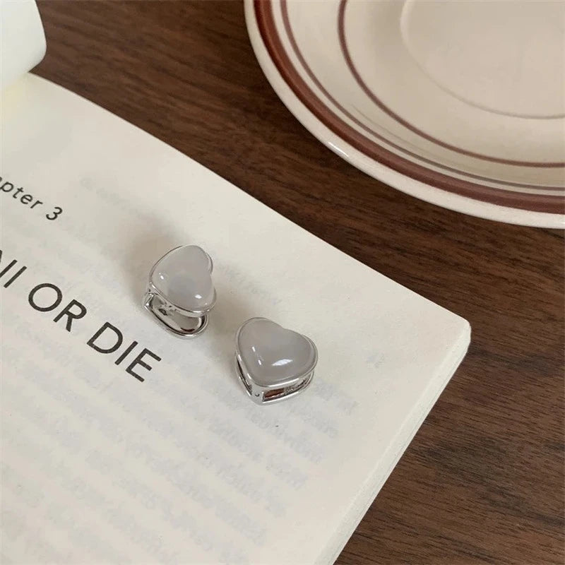 Angled view of the 14K Gold-Plated Double-Sided Heart Earrings