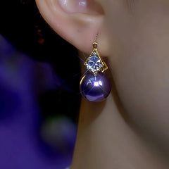 Model showcasing the dangle and style of the 14K Gold-Plated Double-Sided Zircon Purple Pearl Earrings