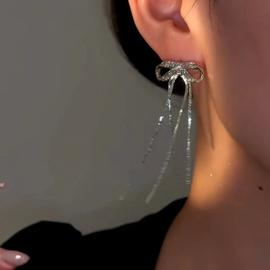 Model showcasing the dangle and style of the 14K Gold-Plated Elegan Zircon Bow Tassel Earrings