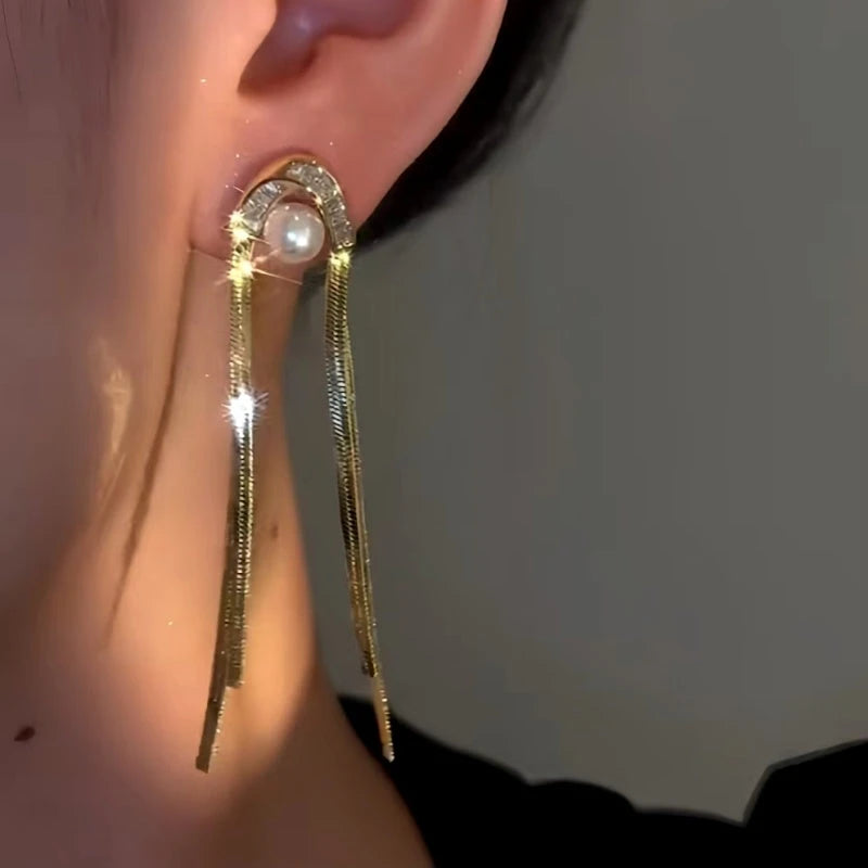 Model showcasing the dangle and style of the 14K Gold-Plated Elegan Zircon Pearl Tassel Earrings