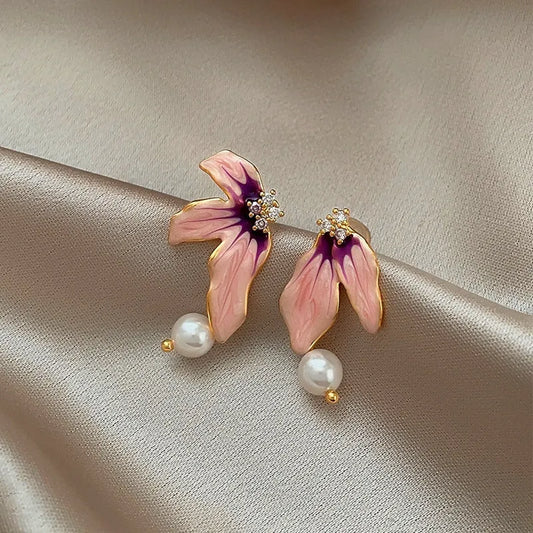 Model showcasing the dangle and style of the 14K Gold-Plated Elegant Asymmetrical Pearl Flower Earrings