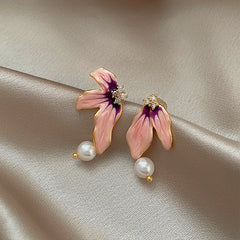 Model showcasing the dangle and style of the 14K Gold-Plated Elegant Asymmetrical Pearl Flower Earrings