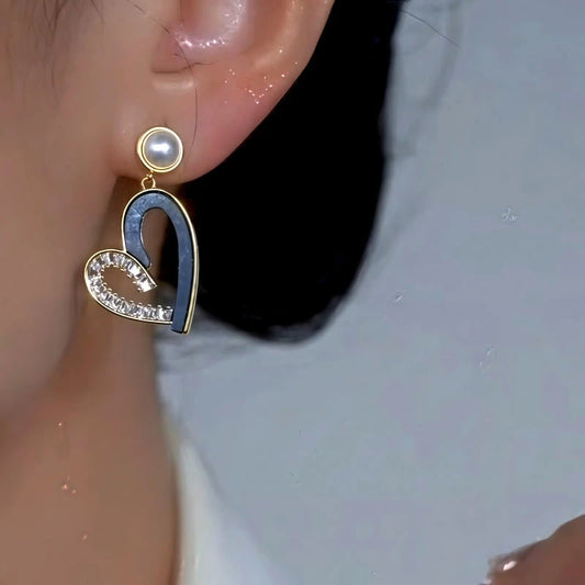 Model showcasing the dangle and style of the 14K Gold-Plated Elegant Asymmetrical Zircon Diamond Heart Pearl Tassel Earrings