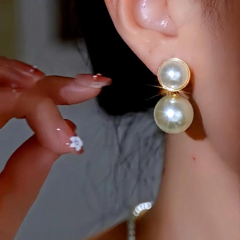 Model showcasing the dangle and style of the 14K Gold-Plated Elegant Bead Earrings