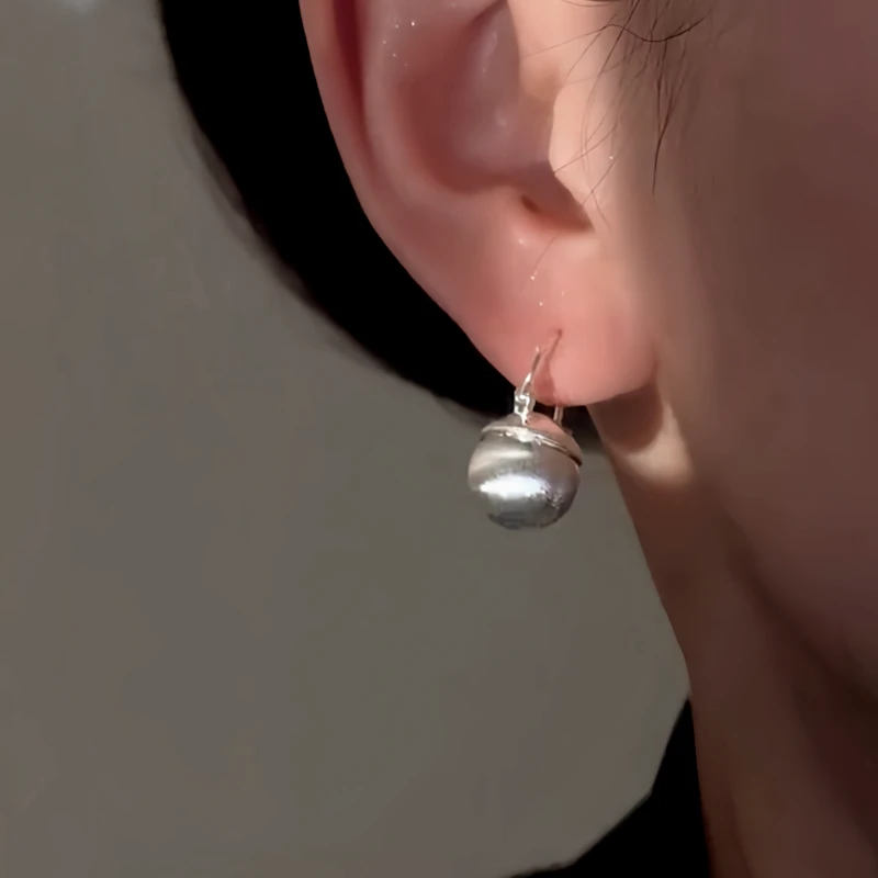 Model showcasing the dangle and style of the 14K Gold-Plated Elegant Bead Earrings