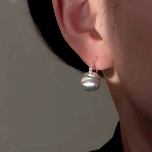 Model showcasing the dangle and style of the 14K Gold-Plated Elegant Bead Earrings