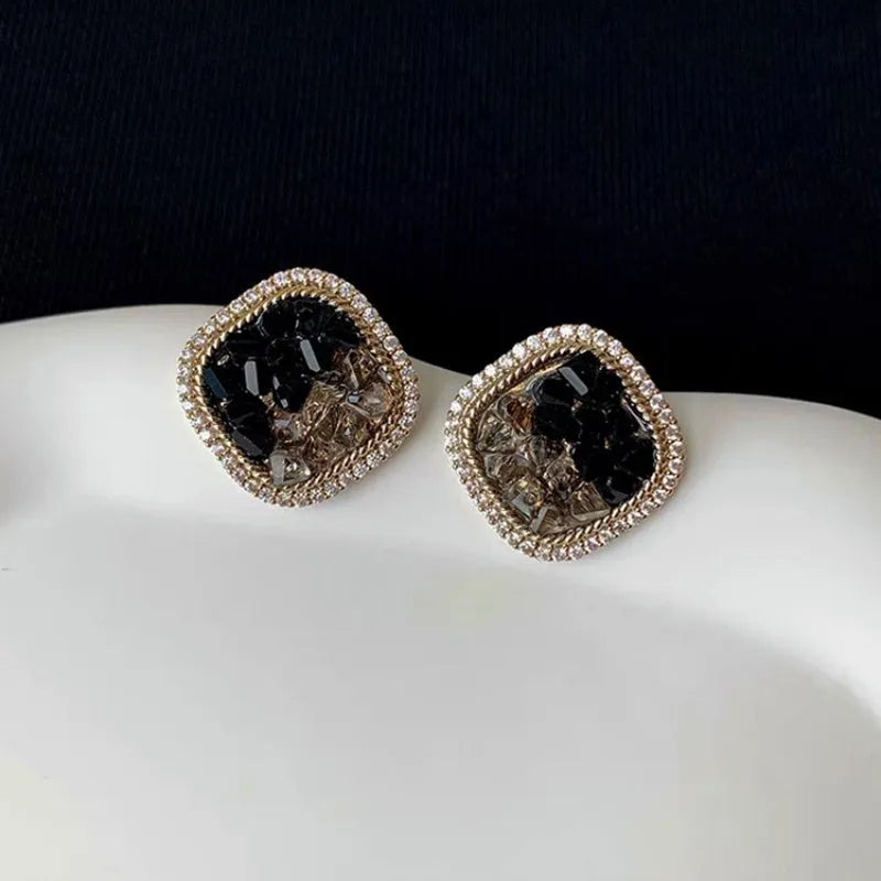 Model showcasing the dangle and style of the 14K Gold-Plated Elegant Black Crystal Zircon Stud Earrings
