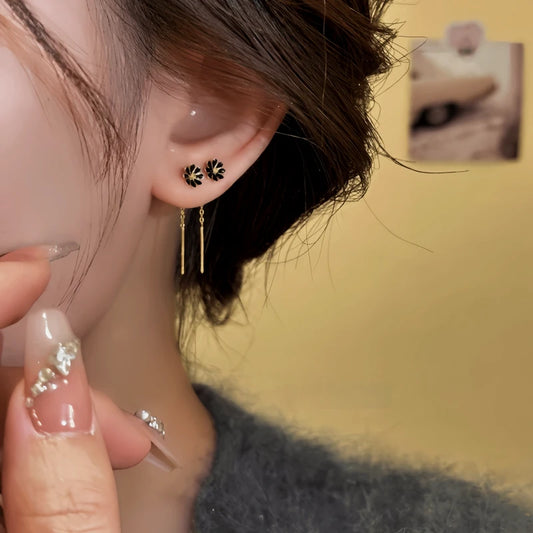 Model showcasing the dangle and style of the 14K Gold-Plated Elegant Black Flower Threader Earrings