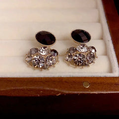 Model showcasing the dangle and style of the 14K Gold-Plated Elegant Black Oval Full Diamond Earrings